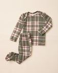A two-piece baby pajama set featuring a long-sleeve top and matching footed pants in an olive green plaid pattern with red and white stripes, laid flat on a light beige background.