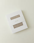 A product packaging shot of the Solly Baby Wrap in a white box with a window showing the Cream Floral print inside.