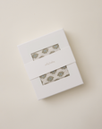 White box with floral design on a beige background
