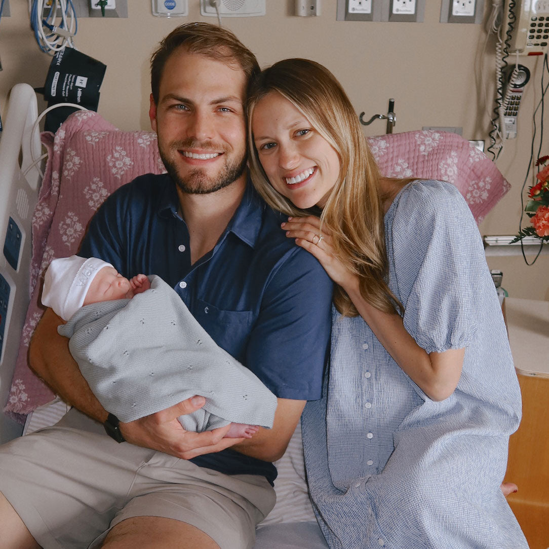 New parents smile and hold their baby boy in the hospital