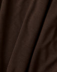 A close-up of draped dark brown fabric with soft folds and a fine knit texture.