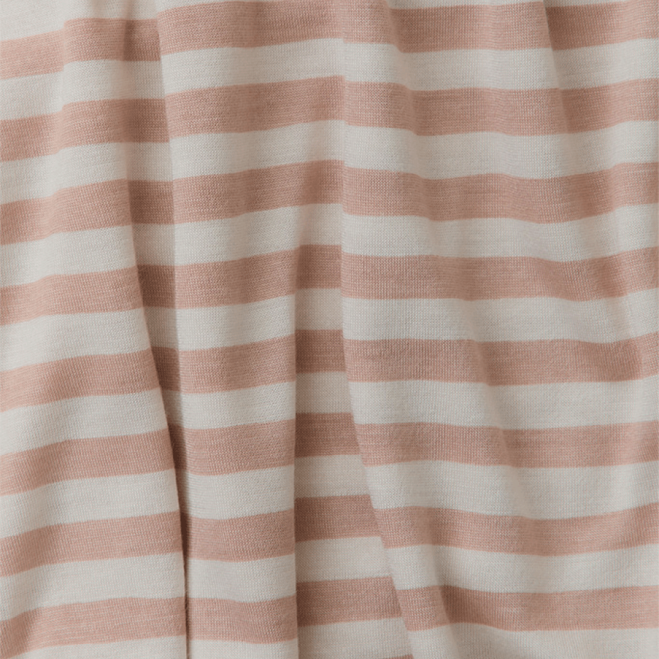 Close-up of Solly Baby's signature fabric in the Candy Stripe colorway, featuring soft blush pink and creamy ivory stripes in a cozy, lightweight knit. The buttery-soft material drapes gently, perfect for wraps, sleepers, or everyday essentials with a timeless, playful design.