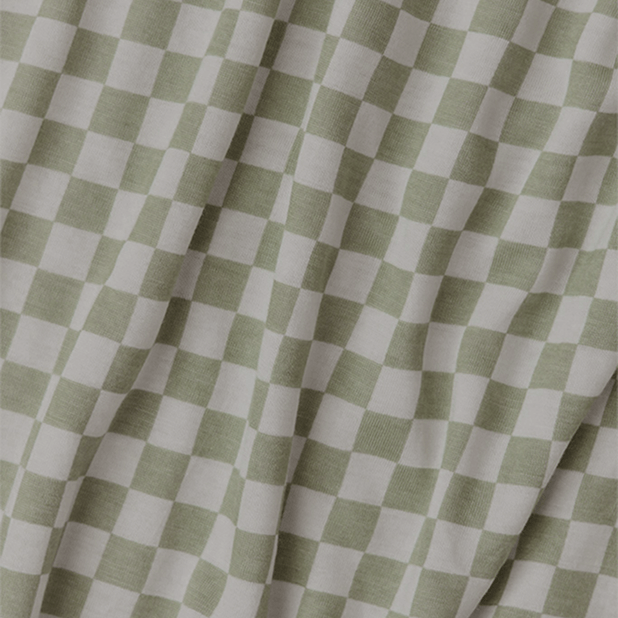 Close-up of Solly Baby's sage green and cream checkerboard fabric. A soft, breathable knit with a playful yet classic design perfect for cozy sleepwear.