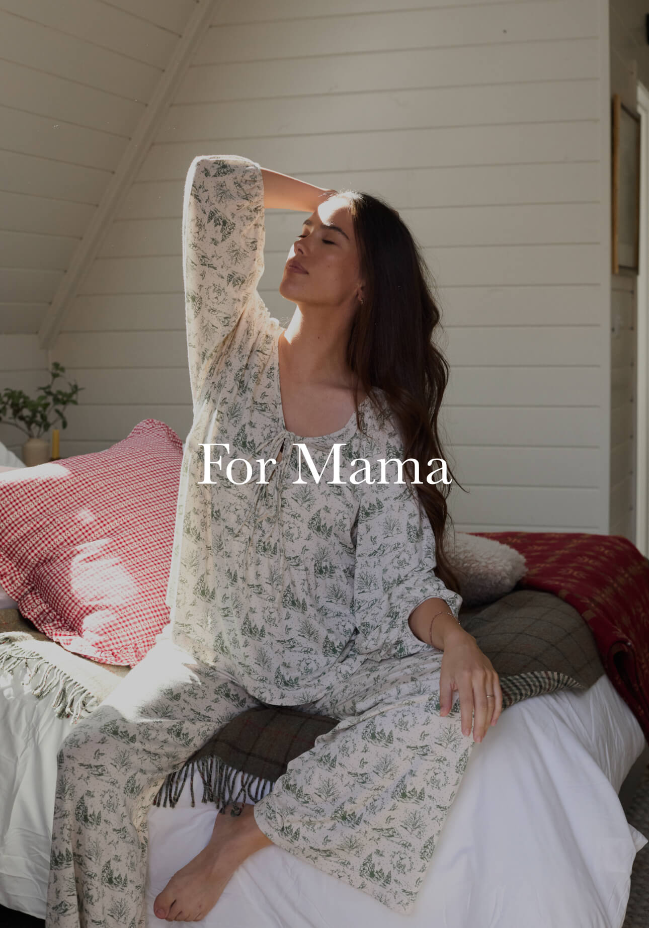 Woman stretching on bed in a soft, winter toile lounge set, enjoying a calm morning light.