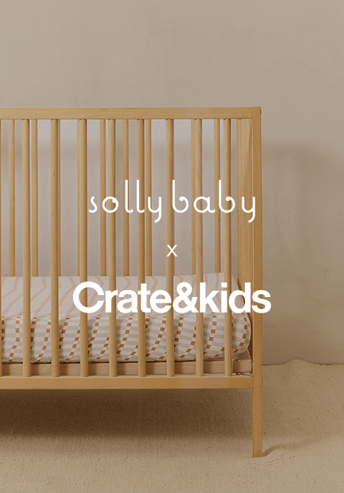 Wooden crib featuring a Solly Baby fitted sheet with a soft peach dot pattern, part of the Crate & Kids collaboration. Cozy, breathable bedding designed for peaceful sleep and timeless nursery styling.