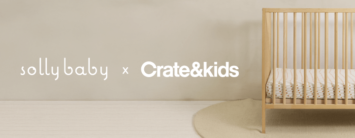 Solly Baby x Crate & Kids collaboration featuring a minimalist nursery scene with a natural wood crib dressed in a patterned Solly Baby crib sheet. A soft, neutral-toned rug adds warmth to the space.