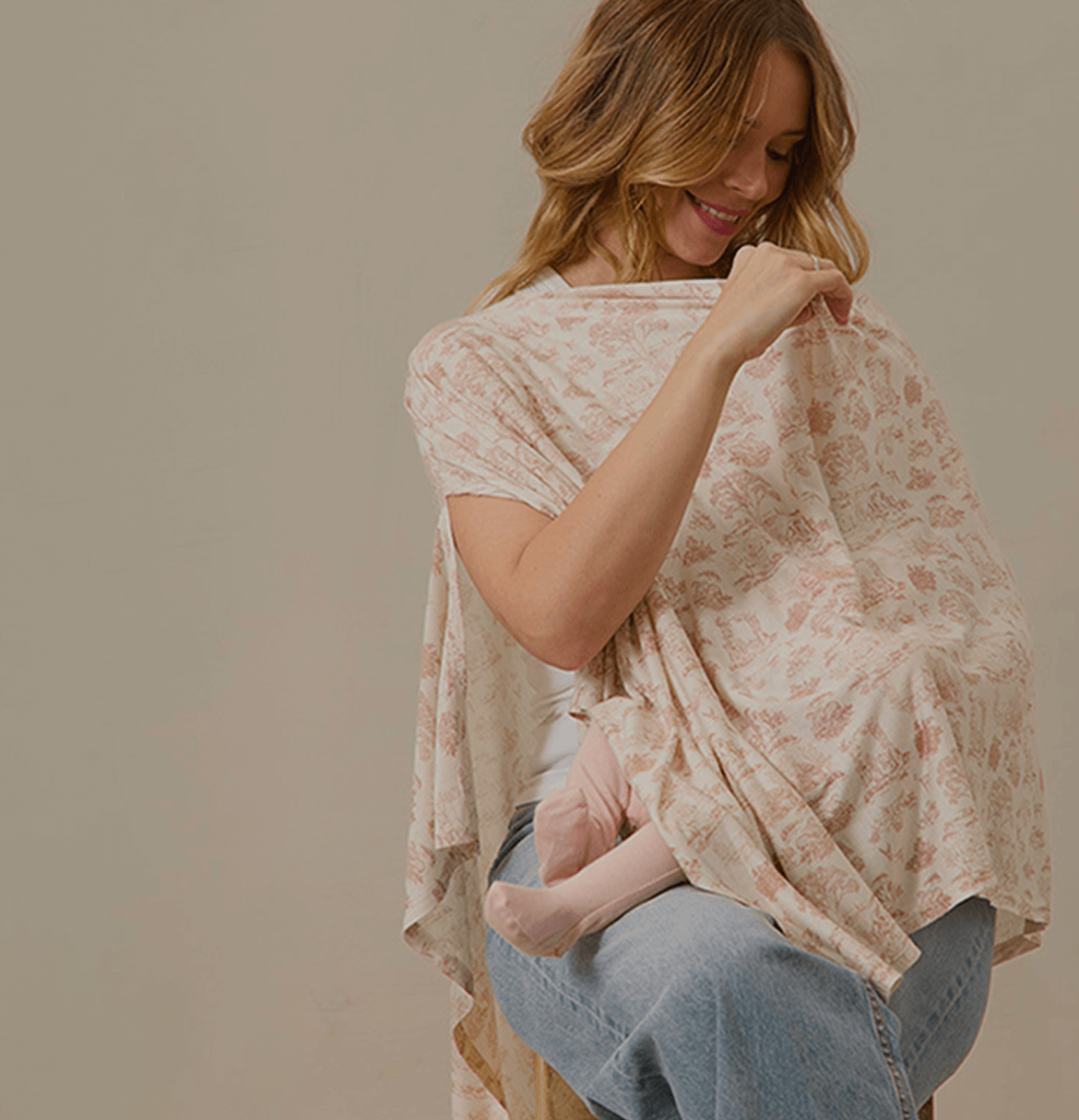 Mother nursing her baby under a Solly Baby Nursing Cover in a soft blush toile print. Made from breathable, ultra-soft TENCEL™ Modal for comfort and effortless coverage.