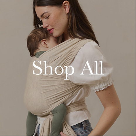 Woman holding a baby in a beige wrap against a plain background with 'Shop All' text overlay.