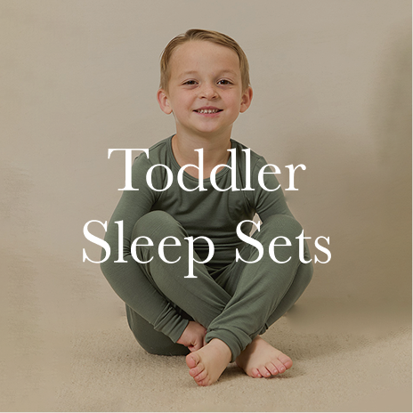 Child wearing a green toddler sleep set with text overlay on a beige background