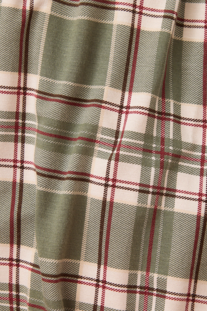 A close-up of a plaid fabric pattern with sage green, cream, and burgundy stripes.