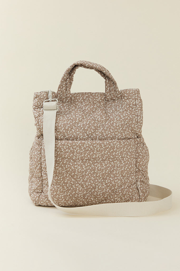 A back-view of the Solly Baby Cream Floral Totepack diaper bag featuring an adjustable strap.