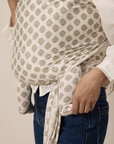 Person wearing a patterned baby carrier with a neutral background